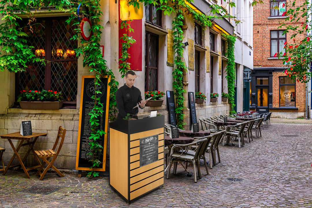 24" Host Station with Slatwall Front and Locking Casters, outside a cafe