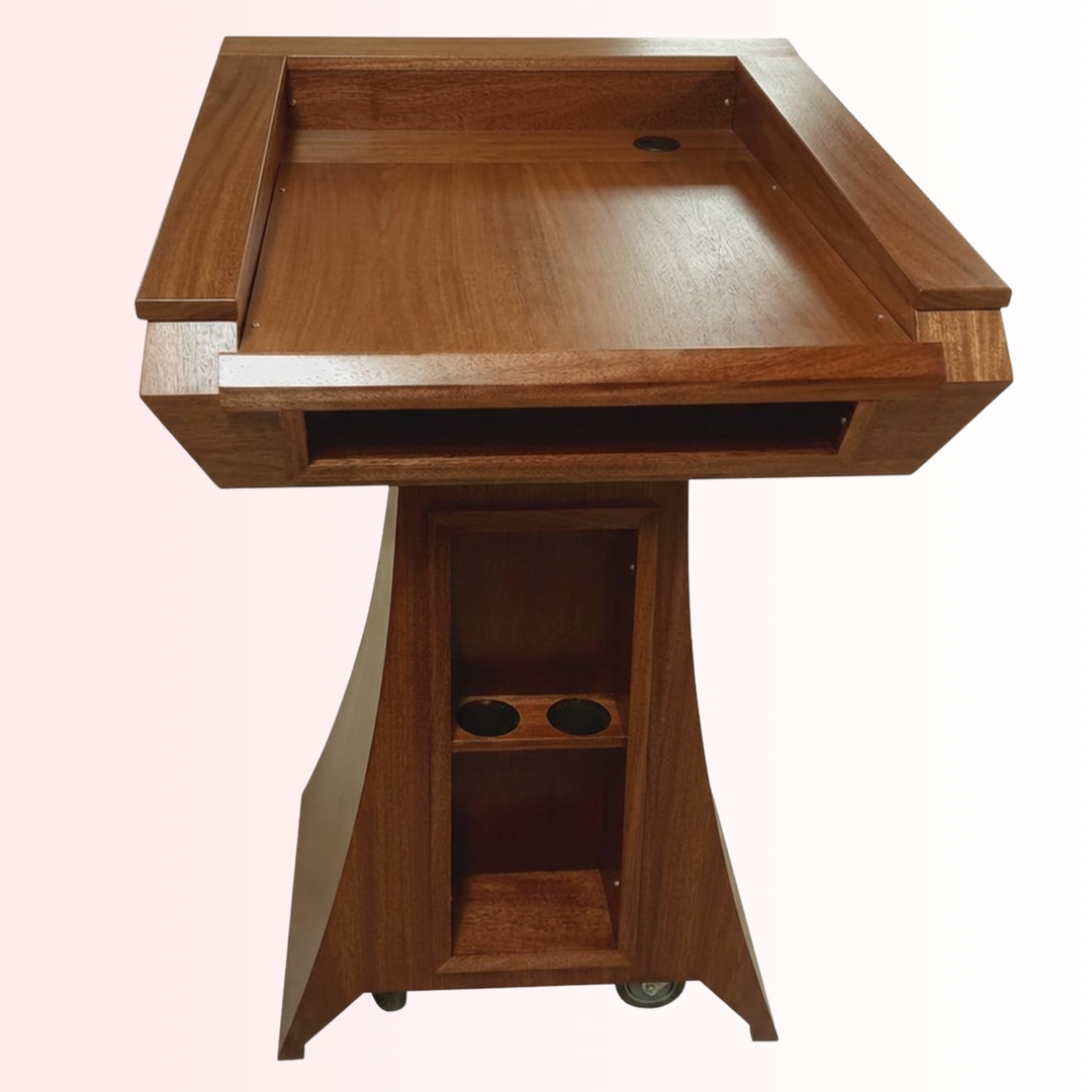 A wooden lectern or podium with a built-in tray on top, open storage compartment on the front, and caster wheels at the base, shown against a plain light background.